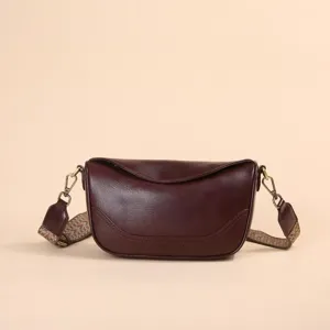 Bolso cruzado vintage de cuero genuino con correa ancha estampada y solapa clásica.