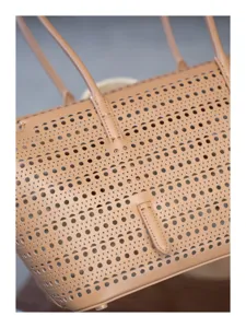 Élégant sac cabas en cuir perforé doté de deux anses et d'un design ajouré chic.