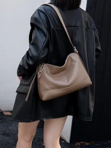 Vista dettagliata di una elegante borsa a spalla in vera pelle marrone con catena metallica.