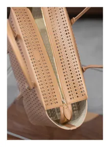 Vue de détail en gros plan du sac à main en cuir perforé de luxe avec un motif découpé élégant.