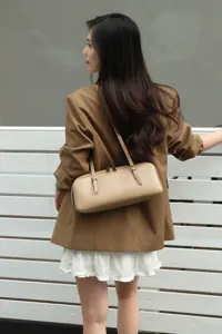Detail view of minimalist genuine leather shoulder bag, elegant baguette style accessory.