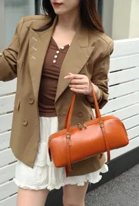 Genuine leather cylindrical shoulder bag for women, stylish underarm baguette bag.