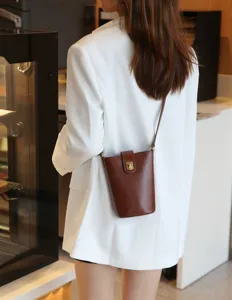 Genuine leather phone crossbody bag detail, brown mini bucket shoulder bag with metal lock.