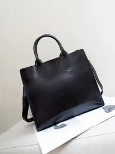 Dettaglio della borsa tote in pelle nera, finitura cerata e stile retrò per uso quotidiano.