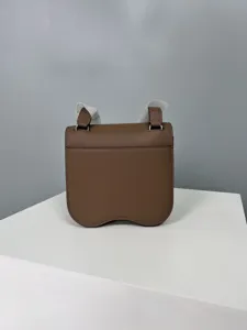 Detailed view of the brown leather saddle bag showcasing palm grain texture and hardware.