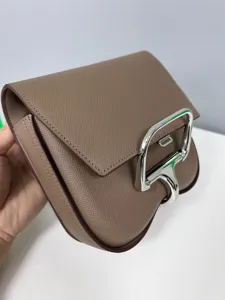 Detailed view of taupe leather saddle crossbody bag, featuring signature silver metal hardware.