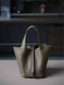 Stijlvolle lederen emmertas met handvatten en sluiting, elegante dagelijkse schoudertas.