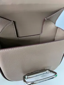 Mini leather saddle bag with distinctive metal clasp closure and elegant top grain texture.