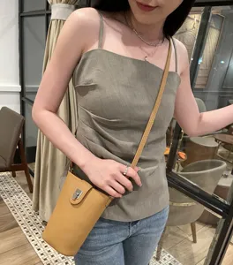 Genuine leather phone crossbody bag detail, compact chic yellow mini shoulder bag style.