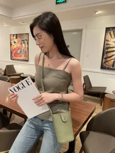 Detailed lifestyle view of green genuine leather crossbody phone bag, minimalist design.