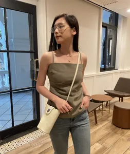 Genuine leather crossbody phone bag detail in cafe scene, elegant minimalist style for women.