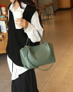 Green genuine leather tote bag detail, soft cowhide shoulder bag lifestyle view display.