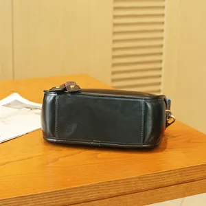 Bottom detail view of black genuine leather vintage pillow bag with clean stitching.