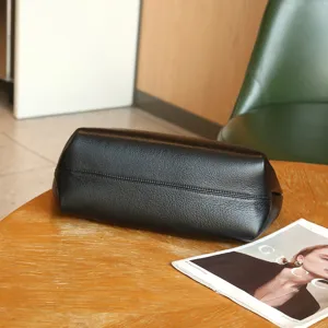 Detailed shot of black genuine leather tote bag, natural milled cowhide texture, premium finish.