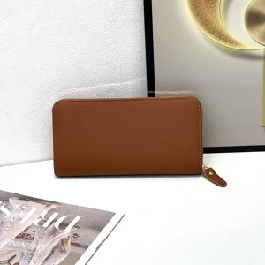 Portafoglio lungo in pelle marrone da donna con chiusura a zip e morbida texture martellata.