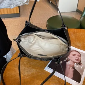 Detailed view of black leather tote bag interior, genuine cowhide, spacious storage.
