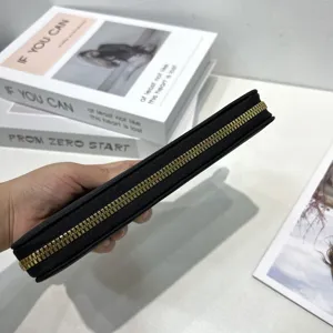 Vista dettagliata del lato con cerniera del portafoglio nero e denti metallici fini.