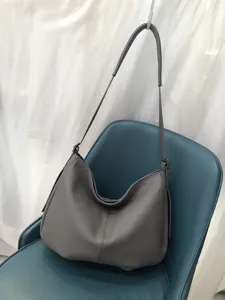 Detailaufnahme der grauen Echtleder Hobo Umhängetasche mit weicher Narbung und Riemen.