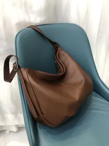 Detailansicht der braunen Echtleder Hobo Umhängetasche zeigt feine Textur und Hardware.