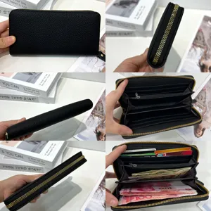 Dettaglio portafoglio lungo in pelle nera, con zip e scomparti multipli per carte e contanti.