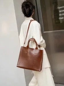 Vista dettagliata della borsa tote in pelle marrone vintage, stile minimal, capiente.
