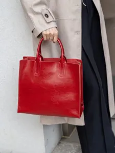 Vista dettagliata della borsa tote vintage in pelle cerata rossa, texture pregiata.