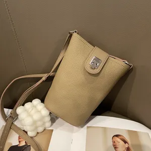 Detail shot of genuine leather mini phone crossbody bag, featuring slim strap and clasp.