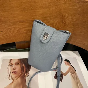 Detail shot of genuine leather phone crossbody bag in light blue with silver hardware.