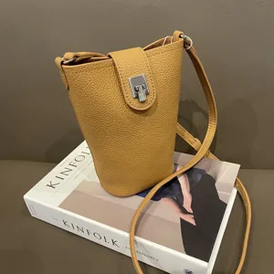 Tan pebbled genuine leather crossbody phone bag detail showing texture and metal lock.