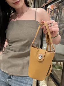 Genuine leather crossbody phone bag for women, stylish yellow vertical mini shoulder bag with lock.