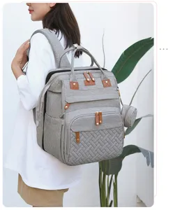 Stylish grey diaper backpack with multi-compartments, leather accents, and comfortable straps.