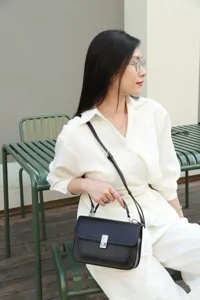 Black leather shoulder bag detail, stylish crossbody small square bag, premium daily use.