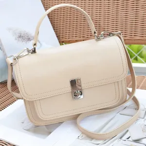 Elegant beige leather crossbody bag with top handle and silver hardware for women.