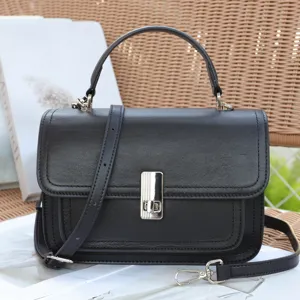 Classic black genuine leather shoulder bag with top handle and stylish metal lock closure.