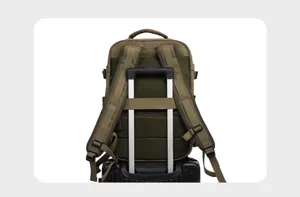 Detail view of the green canvas backpack with breathable mesh back panel and luggage strap.