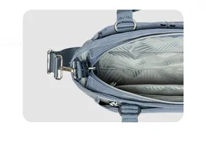 Detailansicht der blaugrauen Damentasche mit mehreren Taschen und Metallbeschlägen.