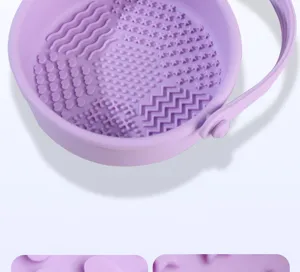 Silicone makeup brush cleaning bowl with multiple textured areas and portable handle tool.