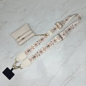 Detailed view of wide embroidered bag strap with coin pouch and adjustable hardware for daily use.