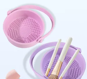 Silicone makeup brush cleaning bowl with multiple textured surfaces and convenient portable handle design.