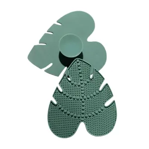 Silicone leaf makeup brush cleaning mat with suction cup for deep and easy cosmetic tool care.