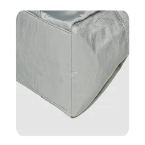 Silver metallic shoulder handbag corner detail showing fine stitching and crinkle fabric texture.