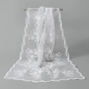 Écharpe longue en dentelle blanche brodée de fleurs avec bordure festonnée élégante.