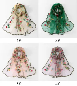 Detailed view of embroidered mesh scarf featuring vibrant floral patterns and elegant wavy edges.