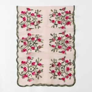 Close-up detail of sheer pink scarf with green embroidered vines and pink floral patterns.