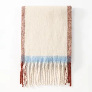 Detailed view of cozy colorblock tassel scarf detail, soft knit texture and fringe accent.