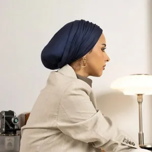 Detailed side view of a solid dark blue elastic knit turban head wrap, elegant design.