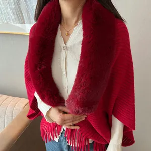 Red knitted shawl detail with plush fur collar and elegant fringe hem for winter wear.