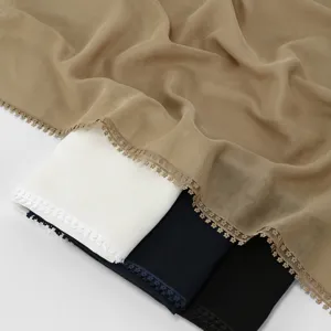 Detail shot of women's long scarf with delicate double-sided lace trim and soft fabric texture.