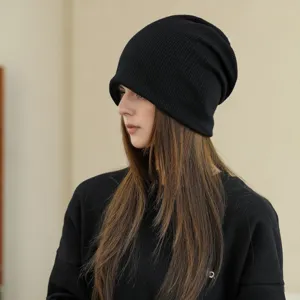 Detail view of the black knit slouchy beanie, featuring soft ribbed texture for winter warmth.