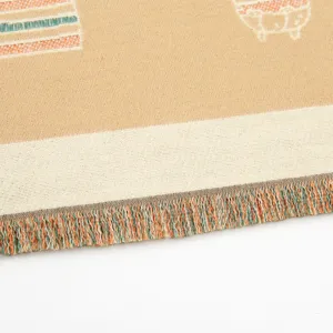 Detailansicht des kuscheligen Strickschals mit Fransen und niedlichem Katzenmuster.
